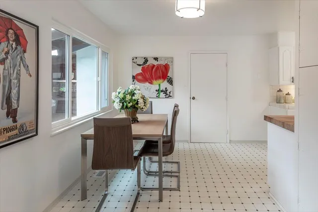 a dining room with furniture and a potted plant