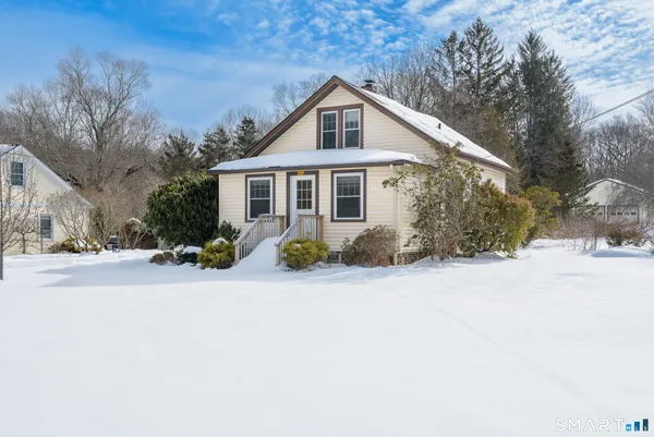 a front view of a house with a yard covered in snow