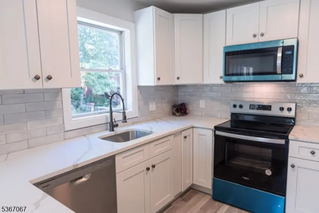 a kitchen with cabinets stainless steel appliances a sink and a microwave