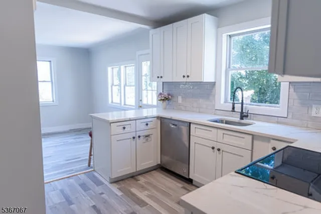 a kitchen with a sink cabinets appliances and a window