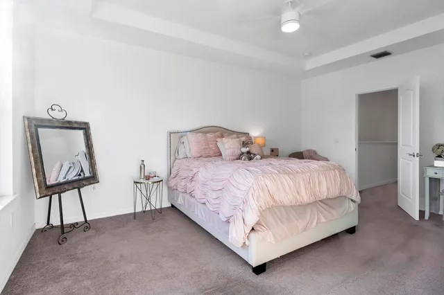 a bedroom with a bed lamp and a mirror