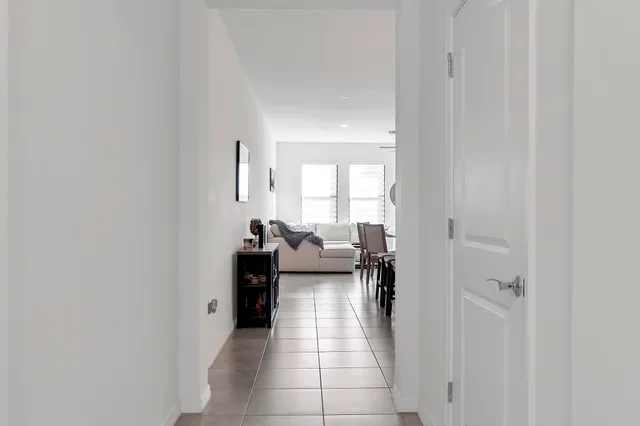 a hallway with white cabinets and couches
