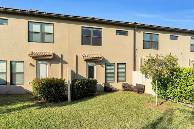 a view of a house with backyard and sitting area