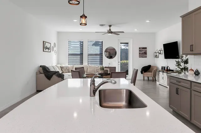 a kitchen with a sink a counter top space a large window and stainless steel appliances