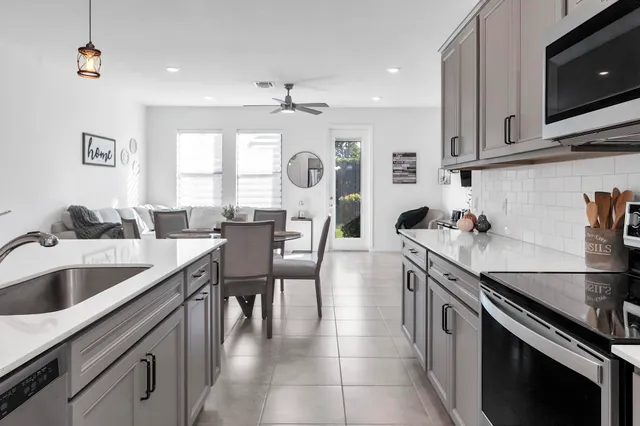 a kitchen with granite countertop a sink a stove and cabinets