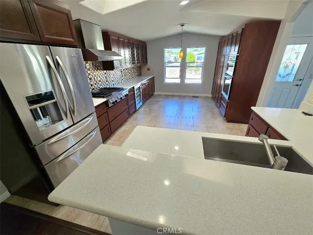 a kitchen with stainless steel appliances a microwave a sink and a refrigerator