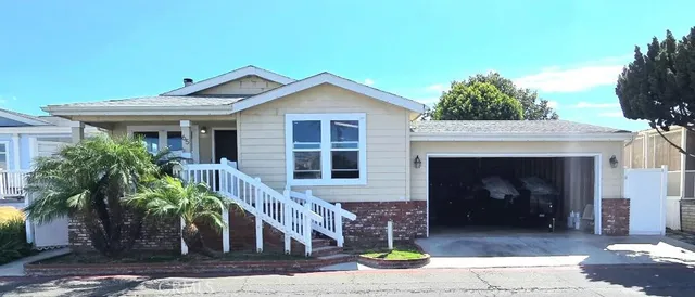a front view of a house with a tree
