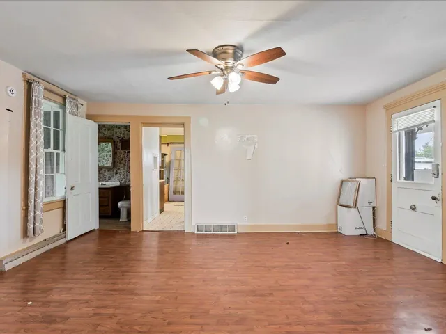 a view of a livingroom with wooden floor and a ceiling fan
