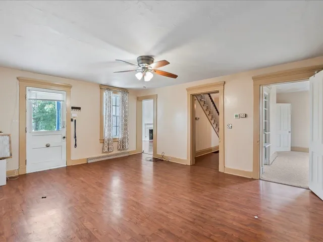 a view of an empty room with a window and wooden floor