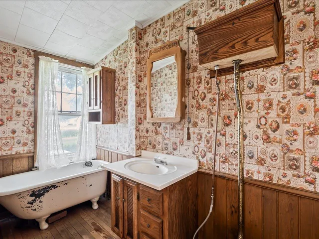 a bathroom with a tub sink and mirror