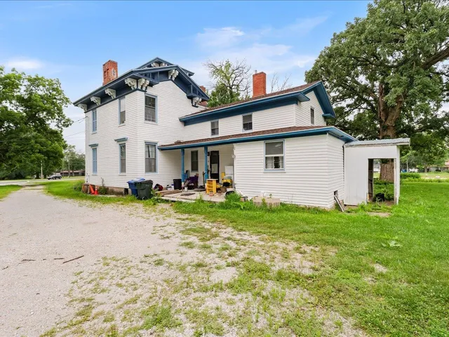 a view of a white house with a yard