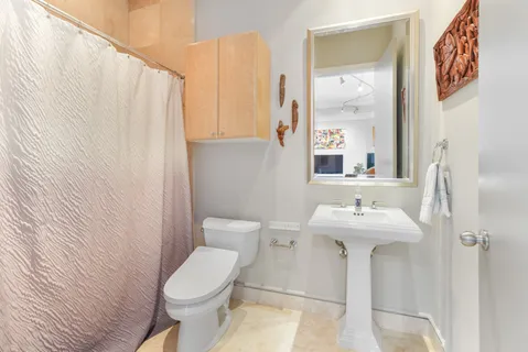 a white toilet sitting next to a bathroom sink