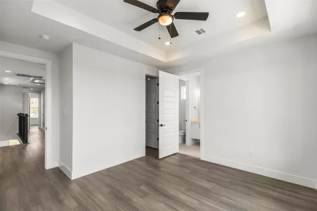a view of a room with wooden floor and ceiling fan