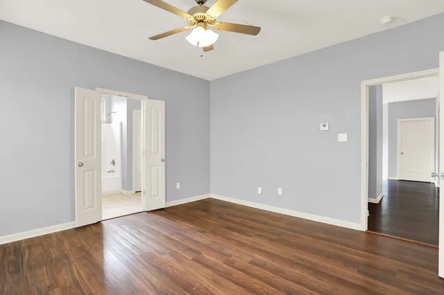 a bedroom with a large bed a chandelier and a potted plant