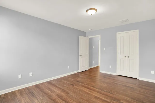 a bedroom with a bed and a painting on the wall