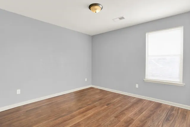 a view of an empty room with wooden floor
