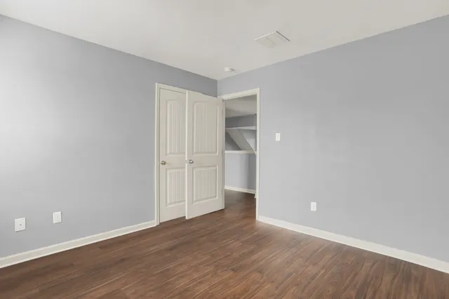 a view of an empty room with wooden floor