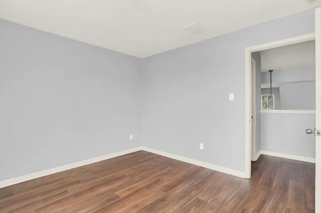a view of an empty room with wooden floor