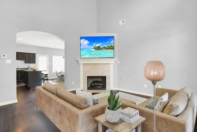 a living room with furniture a fireplace and a flat screen tv