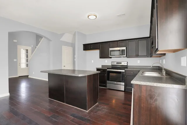 a kitchen with granite countertop a stove top oven and sink