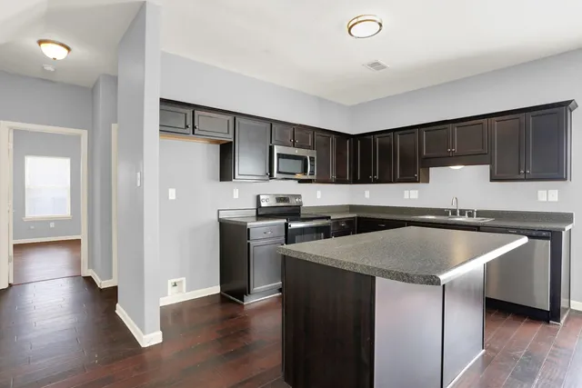 a kitchen with a sink a microwave a refrigerator and cabinets