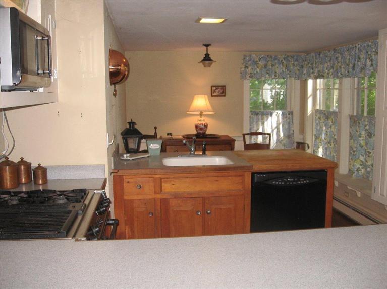 311 Tonset Road Orleans, MA 02653 - Photo 4 of 20 a kitchen with kitchen island granite countertop a sink cabinets and a large window