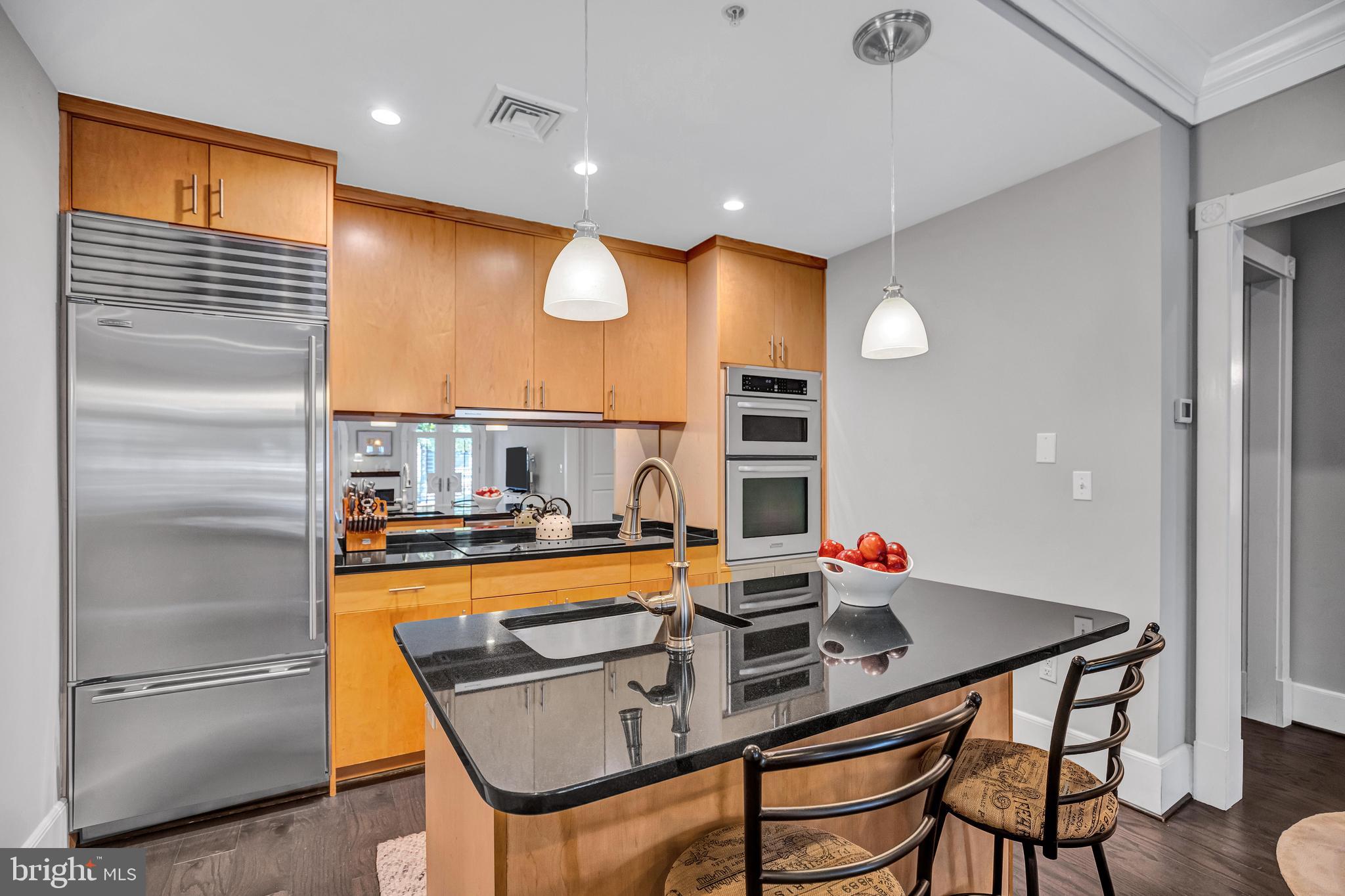 910 Powhatan Street, Unit 104N Alexandria, VA 22314 - Photo 16 of 60 a kitchen with stainless steel appliances granite countertop a sink and a refrigerator