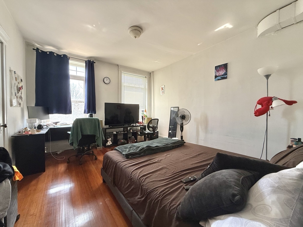 1908 Beacon Street, Unit 2 Brookline, MA 02445 - Photo 12 of 22 a bedroom with a bed and wooden floor