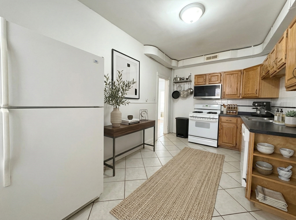 1908 Beacon Street, Unit 2 Brookline, MA 02445 - Photo 21 of 22 a kitchen with stainless steel appliances a refrigerator stove microwave and sink