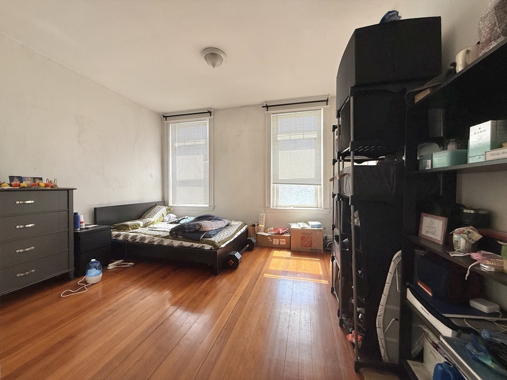 1908 Beacon Street, Unit 2 Brookline, MA 02445 - Photo 6 of 22 a bedroom with a bed and wooden floor