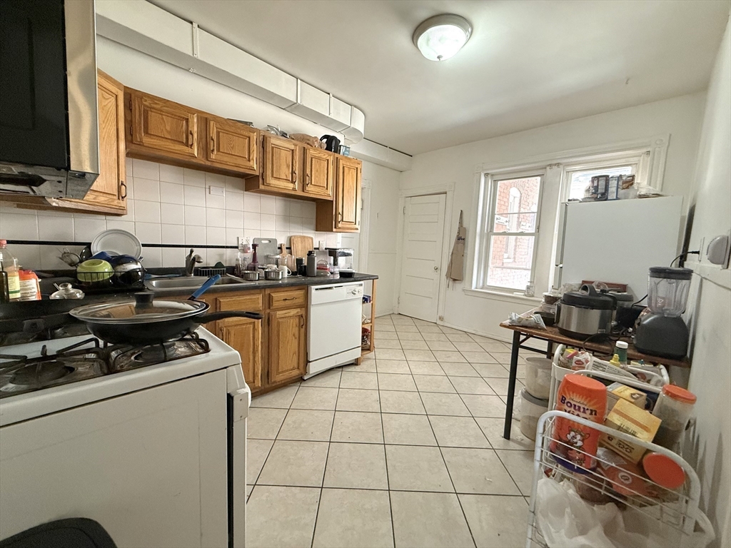 1908 Beacon Street, Unit 2 Brookline, MA 02445 - Photo 9 of 22 a kitchen with stainless steel appliances granite countertop a stove a sink and a microwave