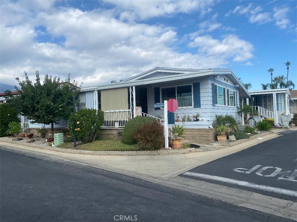 10210 Base Line Road, Unit 51 Alta Loma, CA 91701 - Photo 2 of 19 a front view of house with yard and trees around