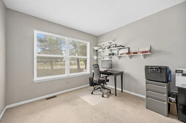 a view of a workspace with furniture and a window