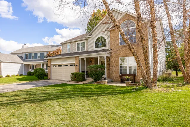 a view of a house with a big yard and large trees