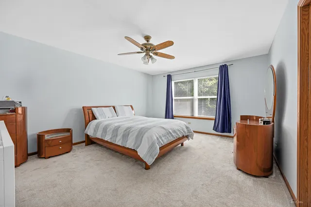 a spacious bedroom with a bed and a chandelier