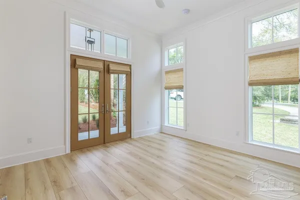 a view of an empty room with wooden floor and cabinet
