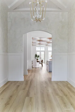 a view of a hallway with furniture and chandelier