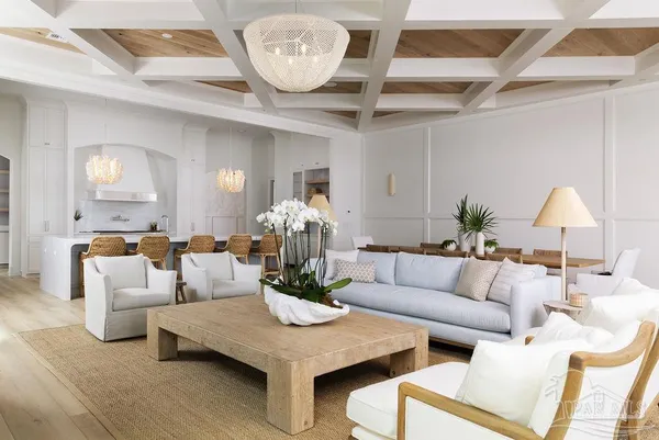 a living room with furniture a chandelier and a large mirror
