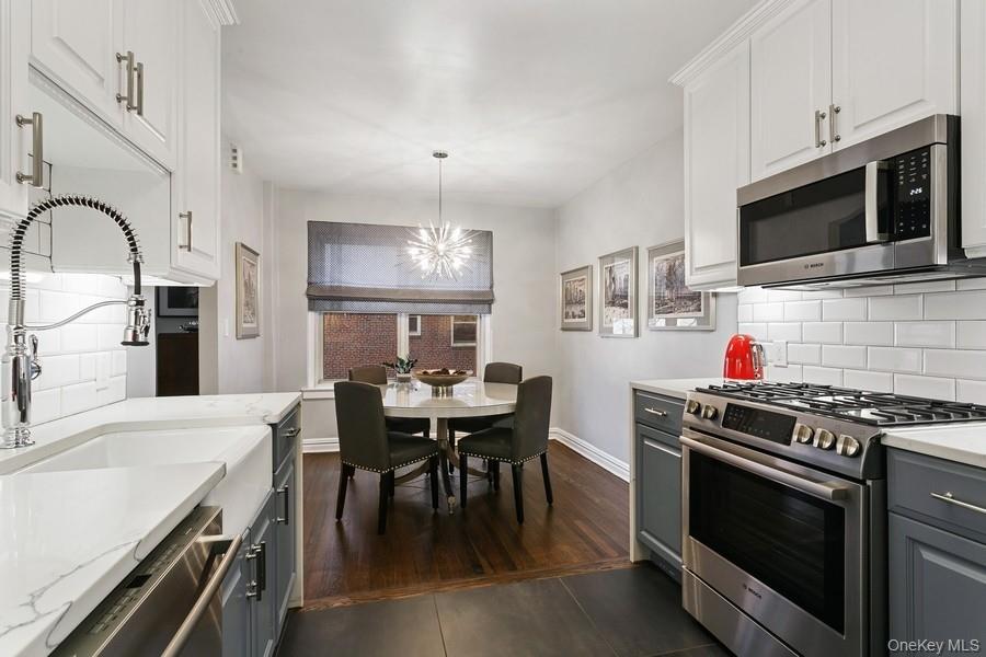 250 Bronxville Road, Unit 3I Bronxville, NY 10708 - Photo 5 of 17 a kitchen with stainless steel appliances kitchen island granite countertop a stove a sink and a microwave
