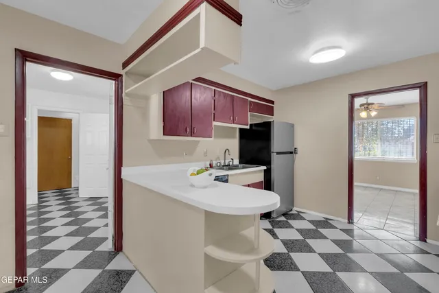 a bathroom with a black white checkered floor and a refrigerator