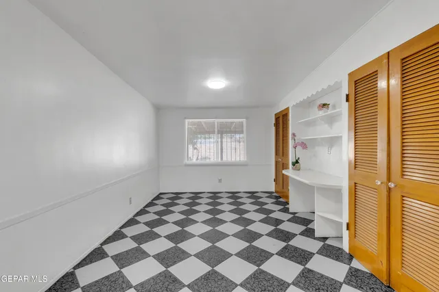 a view of an empty room with a fireplace and a window