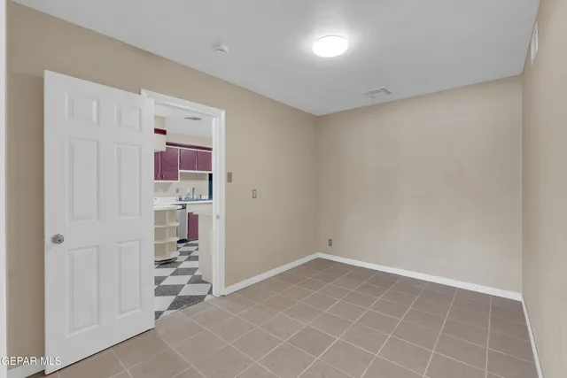 an empty room with kitchen view