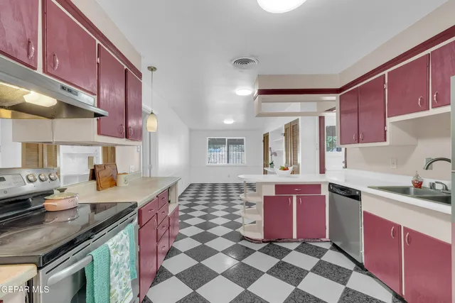 a kitchen with a sink a refrigerator and cabinets