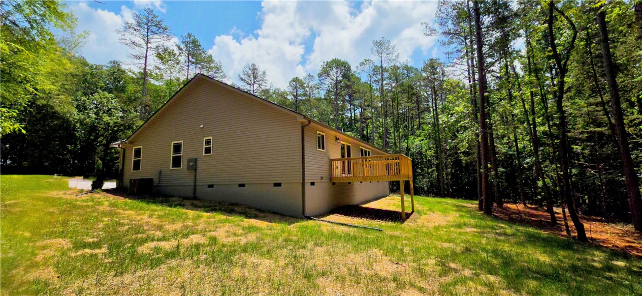 1747 A State Rd S-4-97 Anderson, SC 29621 - Photo 37 of 47 Perched amidst a verdant landscape, this home features an elevated wooden deck, perfect for outdoor relaxation.