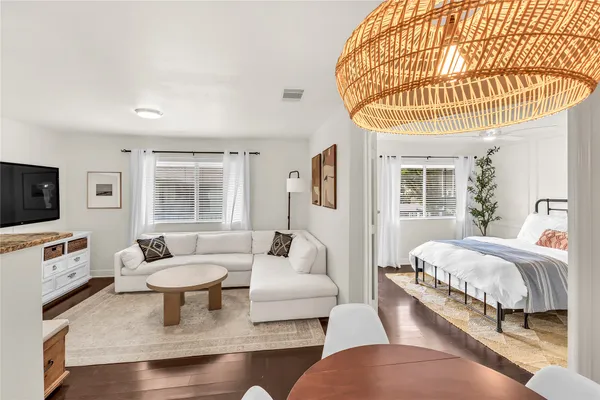 a living room with furniture a flat screen tv and a table