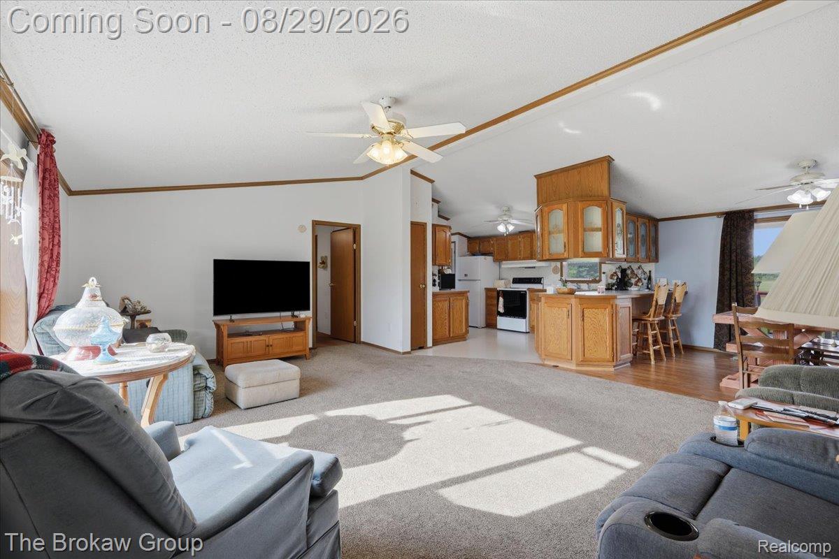 5189 North Webster Road Flushing, MI 48433 - Photo 11 of 46 Open-concept living space featuring vaulted ceilings, wood-finish trim, and ceiling fans