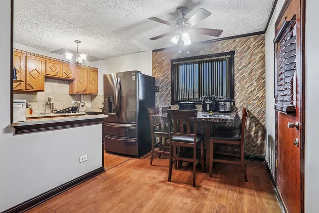 a kitchen with stainless steel appliances kitchen island granite countertop furniture and a refrigerator