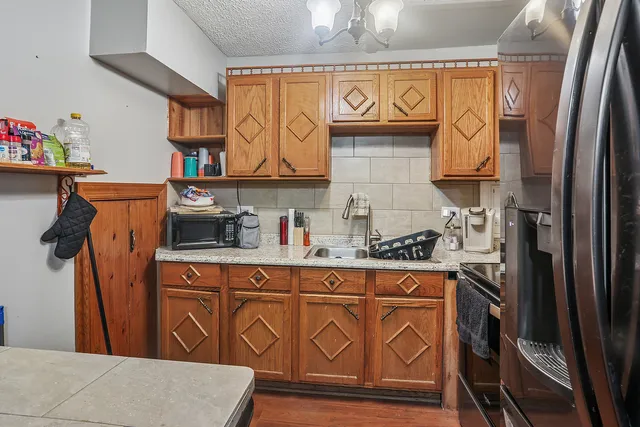 a kitchen with stainless steel appliances granite countertop a refrigerator and a stove