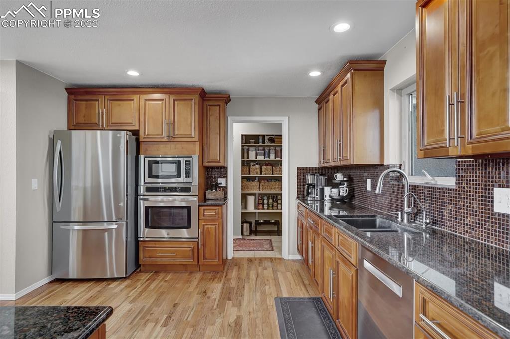 545 Struthers Loop Colorado Springs, CO 80921 - Photo 18 of 44 a kitchen with stainless steel appliances granite countertop a refrigerator and a sink