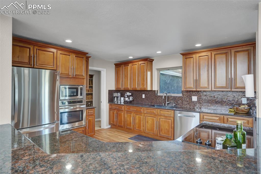 545 Struthers Loop Colorado Springs, CO 80921 - Photo 19 of 44 a kitchen with stainless steel appliances granite countertop a refrigerator and a stove top oven